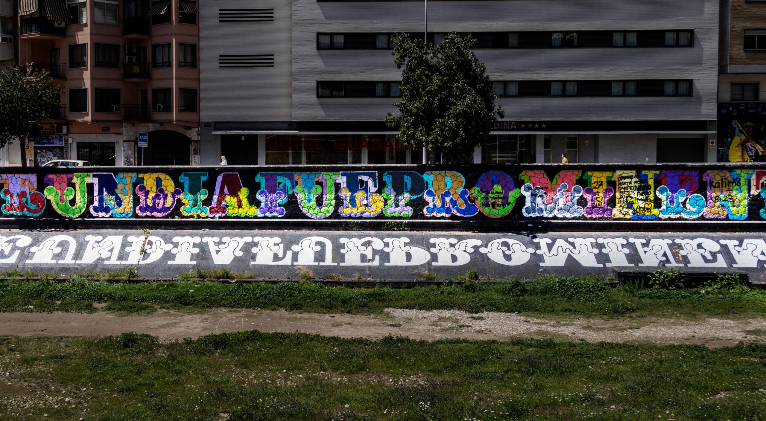 130 meter langt murmaleri af den engelske grafittikunstner Ben Eine løber langs den udtørrede flodbred til højre for broen El Perchel ved CAC-museet.