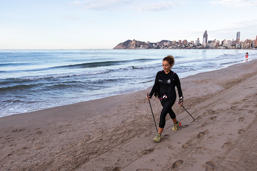 Levántate temprano y practica marcha nórdica en la playa desierta de Benidorm.